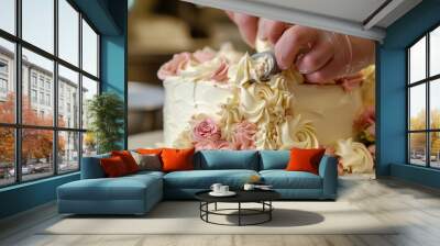 Pastry chef uses a piping bag to create beautiful buttercream roses on a two tiered cake, showcasing their skill and artistry Wall mural