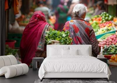 Two elderly women wearing traditional dresses walk away from the camera arms full of freshlypurchased produce from the bustling . . Wall mural