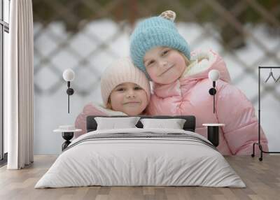 Cozy Winter Companions: Two Little Girls in Stylish Coats and Hats Wall mural