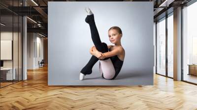 A little adorable young ballerina poses in studio Wall mural