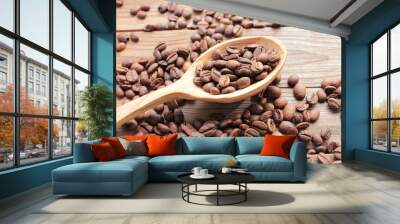 Freshly roasted coffee beans in wooden spoon on wood background. Rustic style Wall mural