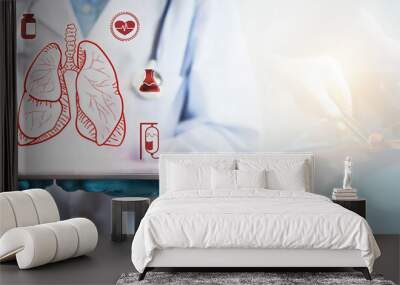 Concept of lung disease treatment. A doctor's hand holding a tablet showing a lung icon. Wall mural