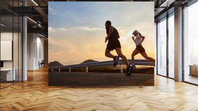 Two people running at sunset. Wall mural