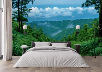 A lush green forest with a winding road leading through it Wall mural