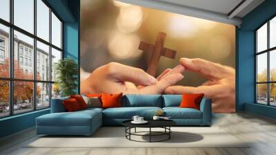 Christian proselytizing, hands of Christian man holding and passing wooden cross to woman's hands, great commission concept. Wall mural