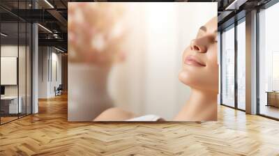 Close up of a beautiful young woman relaxing on massage spa treatment on blurred bright salon background with copy space. Wall mural