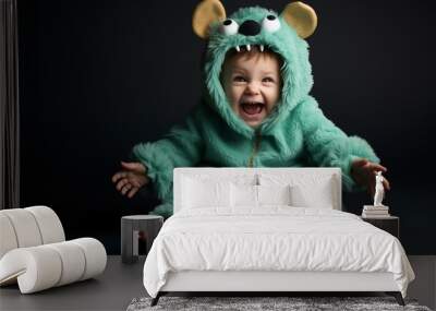 Cute baby boy in halloween monster costume with fun expression on face isolated on dark background, with copy space. Wall mural