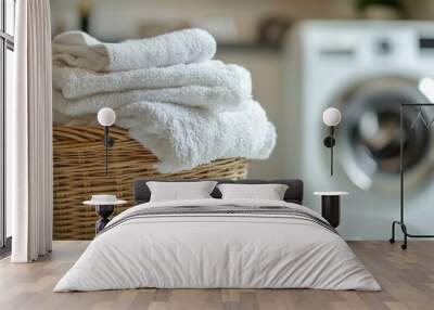 Laundry basket full of folded white clean towels on blurred modern laundry room with blurred washing machine Wall mural