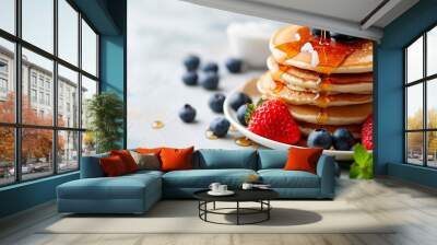 Pancakes with fresh strawberries, blueberry and maple syrup for a breakfast, honey pouring on delicious homemade pancakes with copy space. Wall mural