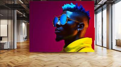 Yellow and purple neon lighted portrait of young and sexy Arican American man with stylish sunglasses in high colored jacket, colorful short curly hair, with copy space. Wall mural