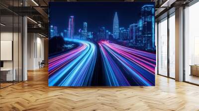 High-speed light trails on a city background with futuristic neon colors, a night view of tall skyscraper buildings and a highway road in a modern urban business district. Wall mural