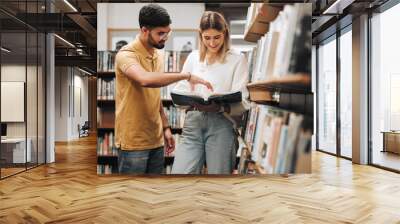 Students, library and discussion for man, woman or book for knowledge, learning or information in university. Bookshelf, conversation and reading for college student, friends or education for success Wall mural