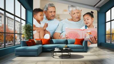 Treat your family like friends and your friends like family. Shot of grandparents bonding with their grandchildren on a sofa at home. Wall mural