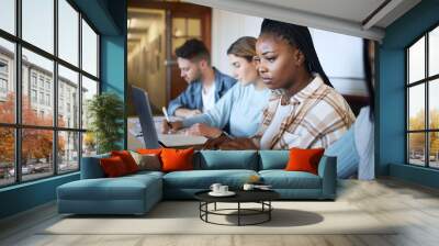 University, education and group of students at desk doing project, studying and learning with laptop and notebook. Academy, college and young people taking notes in classroom, study group and lecture Wall mural