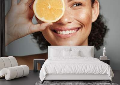 Woman, smile and orange in studio for skincare, health and wellness with cosmetic glow, self care and backdrop. Model, black woman and fruit for cosmetics, detox or healthy natural skin by background Wall mural