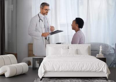 Consulting, medical and doctor with black woman in hospital for checklist, examination and therapy. Appointment, interview and help with healthcare worker listening to patient for physician checkup Wall mural