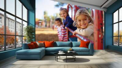 happy young children playing on playground equipment  Wall mural