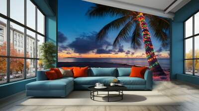 Palm tree decorated in colorful christmas lights on tropical beach at sunset with copy space
 Wall mural