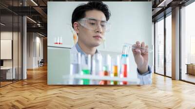 concept of medical, chemicals or scientific laboratory research and Innovation in the laboratory. experienced handsome Asian man scientist is performing work in the laboratory. Wall mural