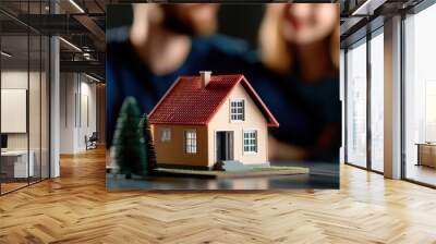 Couple dreams of home ownership, focusing on a miniature house symbolizing love and stability in their future. Wall mural