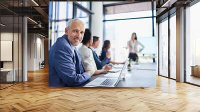 Happy CEO, boss or chairman looking confident in a team meeting at work. Portrait of a proud employee with colleagues as they discuss new innovative plans and strategy in a corporate office Wall mural