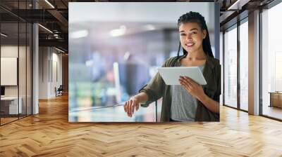 My device shows me we making great progress. Shot of a young businesswoman using a tablet at the office. Wall mural