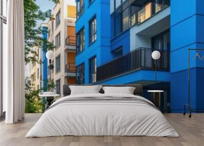 A blue apartment building with a green walkway in front of it Wall mural