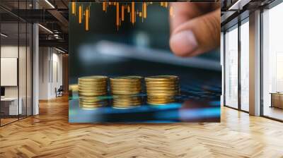 A hand is reaching for a stack of gold coins on a table Wall mural