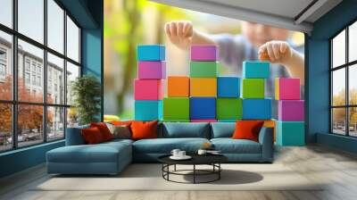 A young boy is playing with a tower of colorful blocks Wall mural