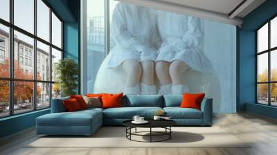 Two women in white clothing sit on a ball Wall mural