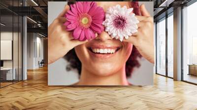 Woman, face and flower eyes with smile for natural skincare, beauty or cosmetics isolated on a grey background. Happy female, person or lady smiling in happiness holding colorful plant petals for art Wall mural