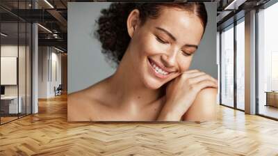 Face, beauty and skin with a model black woman in studio on a gray background to promote natural care. Facial, wellness and makeup with an attractive young female happy with her skincare product Wall mural