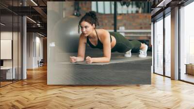 Fitness, gym and workout of a woman doing plank exercise or training for wellness with focus for healthy lifestyle. Female athlete with body weight routine for strong core, sports health and balance Wall mural