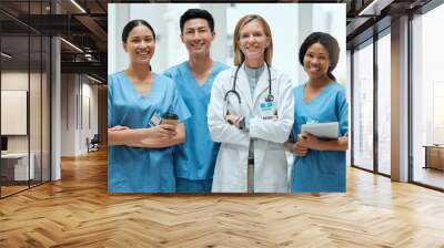 Portrait, medical and a woman doctor arms crossed, standing with her team in the hospital for healthcare. Leadership, health and teamwork with a female medicine professional in a clinic for treatment Wall mural