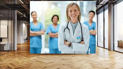 Portrait, team and a doctor woman arms crossed, standing in the hospital for healthcare or medicine. Leadership, medical or teamwork with a mature female health professional in a clinic for treatment Wall mural