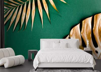 Gold tropical palm leaves Monstera on green background. Flat lay, top view minimal concept. Wall mural