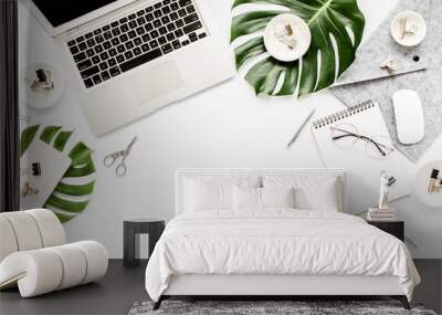 Home office workspace mockup with laptop, tropical leaves Monstera, clipboard, notebook and accessories on white background. Flat lay, top view Wall mural