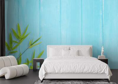 Bamboo leaves on blue wood background Wall mural