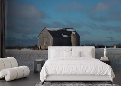 Barn in snowy field during winter Wall mural