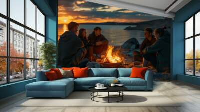 A group of young people sitting around a campfire on the beach. Vacation with friends in nature. Wall mural