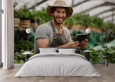 Confident smart farmer using tablet to monitor crop growth on farm, Sustainable digital farming Wall mural