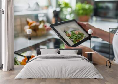 Woman looking at online food cooking recipes with tablet at kitchen table. Wall mural