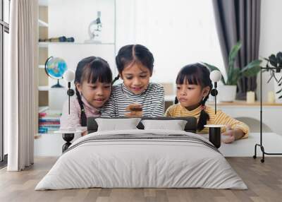 three sibling Asian girl playing wooden stacks at home Wall mural