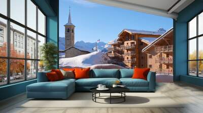 Church and wooden houses in Tignes village ski resort, France, in Winter, with a clear blue sky. Tourism, skiing, hotels, ski-in ski-out. Wall mural