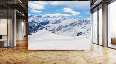 Les Sybelles ski slopes and surrounding white mountain peaks, on a sunny Winter day - panorama in the French alps. Wall mural