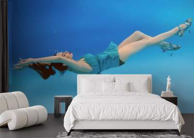 surreal, concept, art portrait of beautiful gorgeous brunette young woman with make up underwater in the swimming pool on blue background  Wall mural