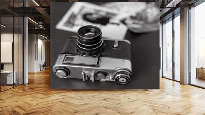 vintage film camera with black and white pictures laying on the table. Vintage, film, old technology concept Wall mural