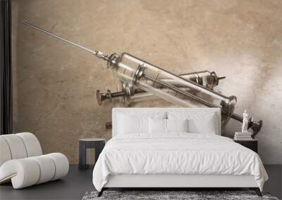 Two vintage glass syringe with a needle for injection lie on the medical table Wall mural