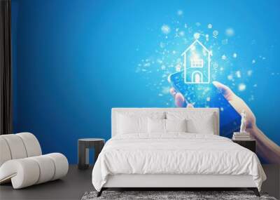 Hand holding smartphone with house icon on blue background, real estate app concept. Home technology and home security technology for digital property management services Wall mural