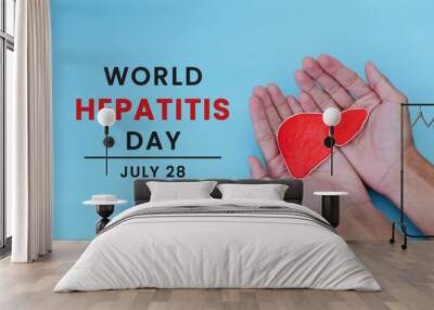 World Hepatitis Day on July 28. Man's hand holding paper heart symbol on light blue background. Concept of heart donation, prevention and treatment of viral hepatitis. Heart cancer. Wall mural